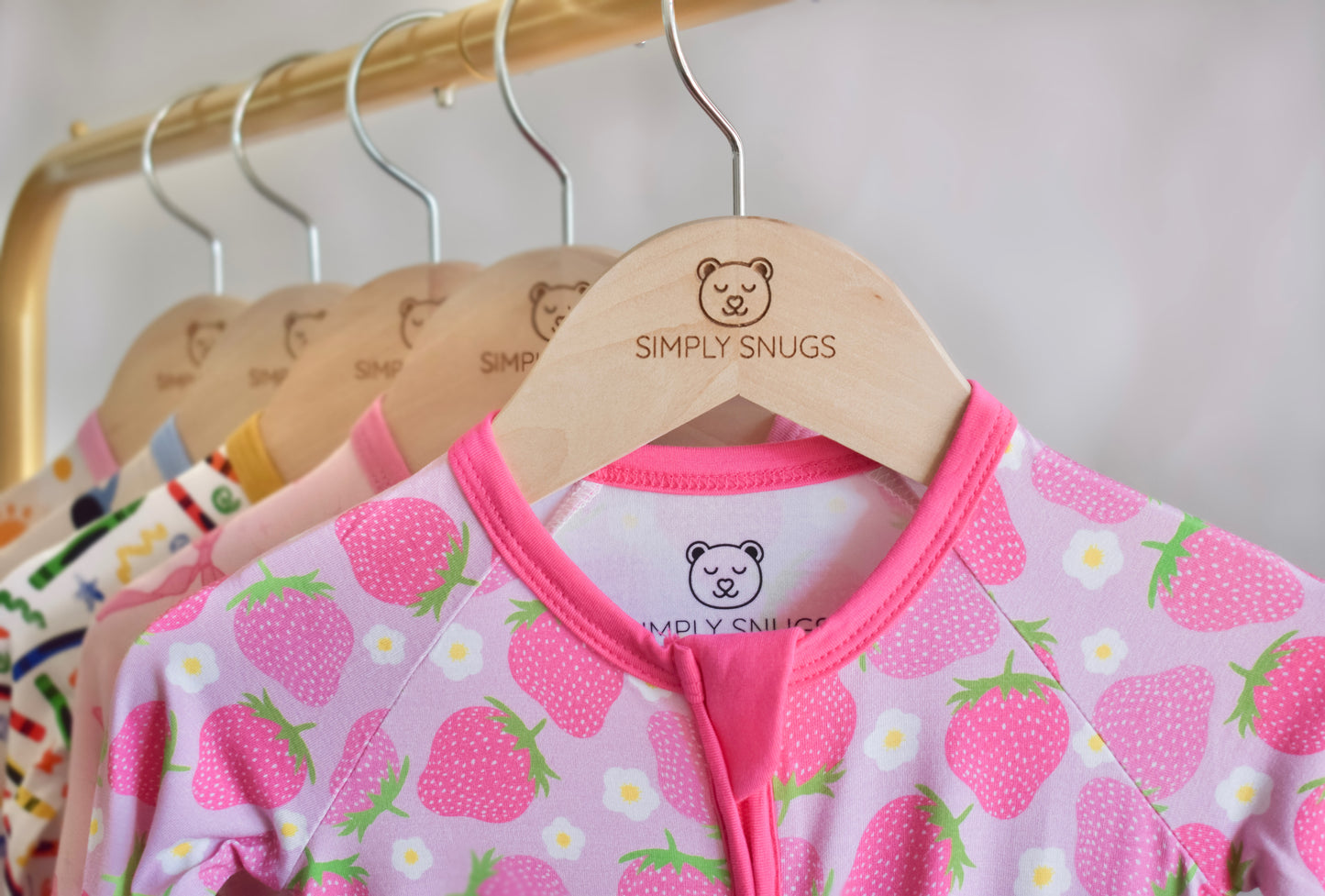 Children's clothing on hangers with 'Simply Snugs' branding unique prints