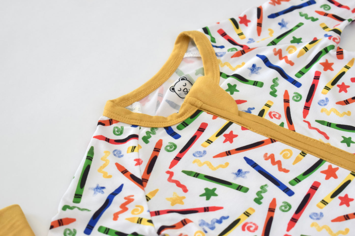 Baby pajama with colorful crayon pattern on a white background