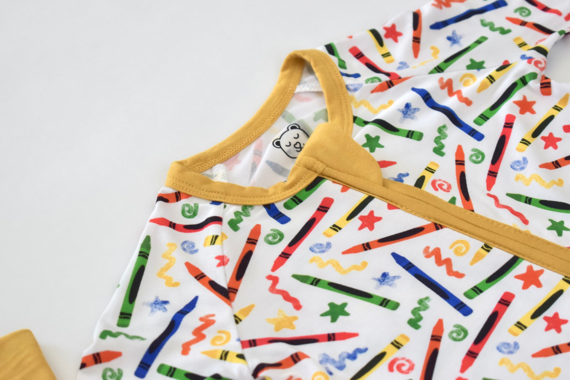 Baby pajama with colorful crayon pattern on a white background