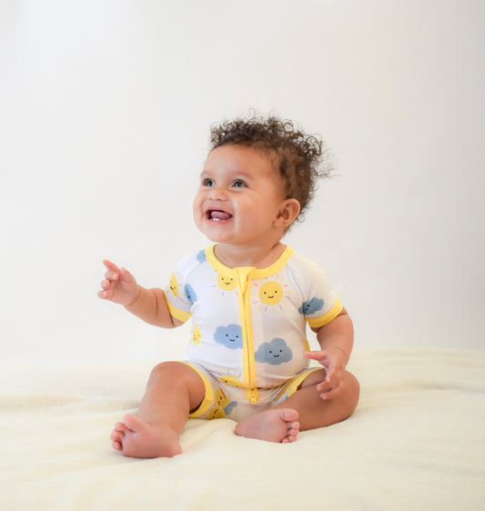 Baby wearing soft shortie pajama with sun and clouds print