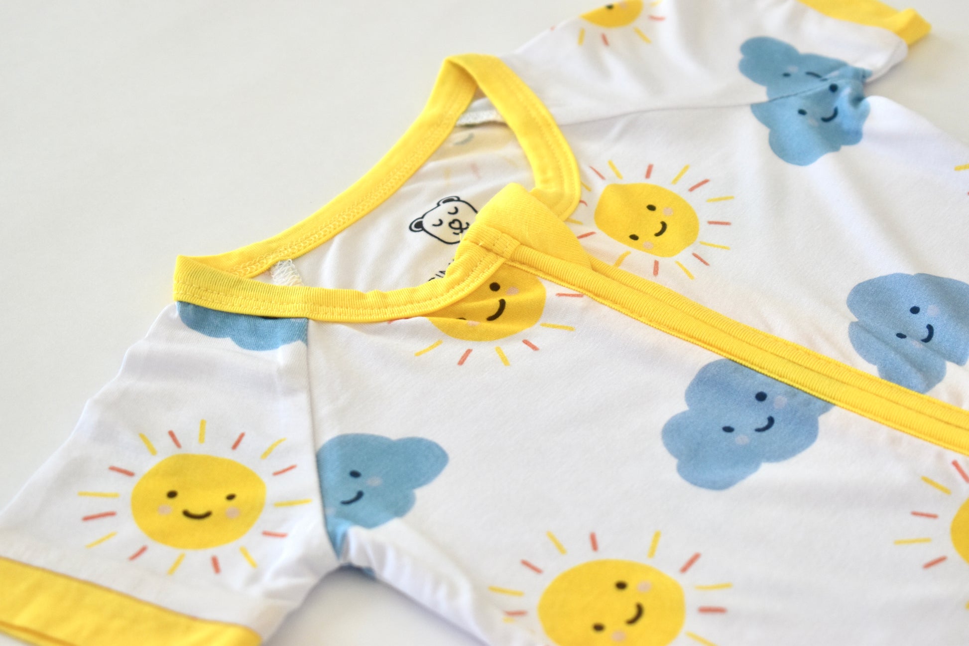 Baby pajama with sun and cloud patterns on a white background