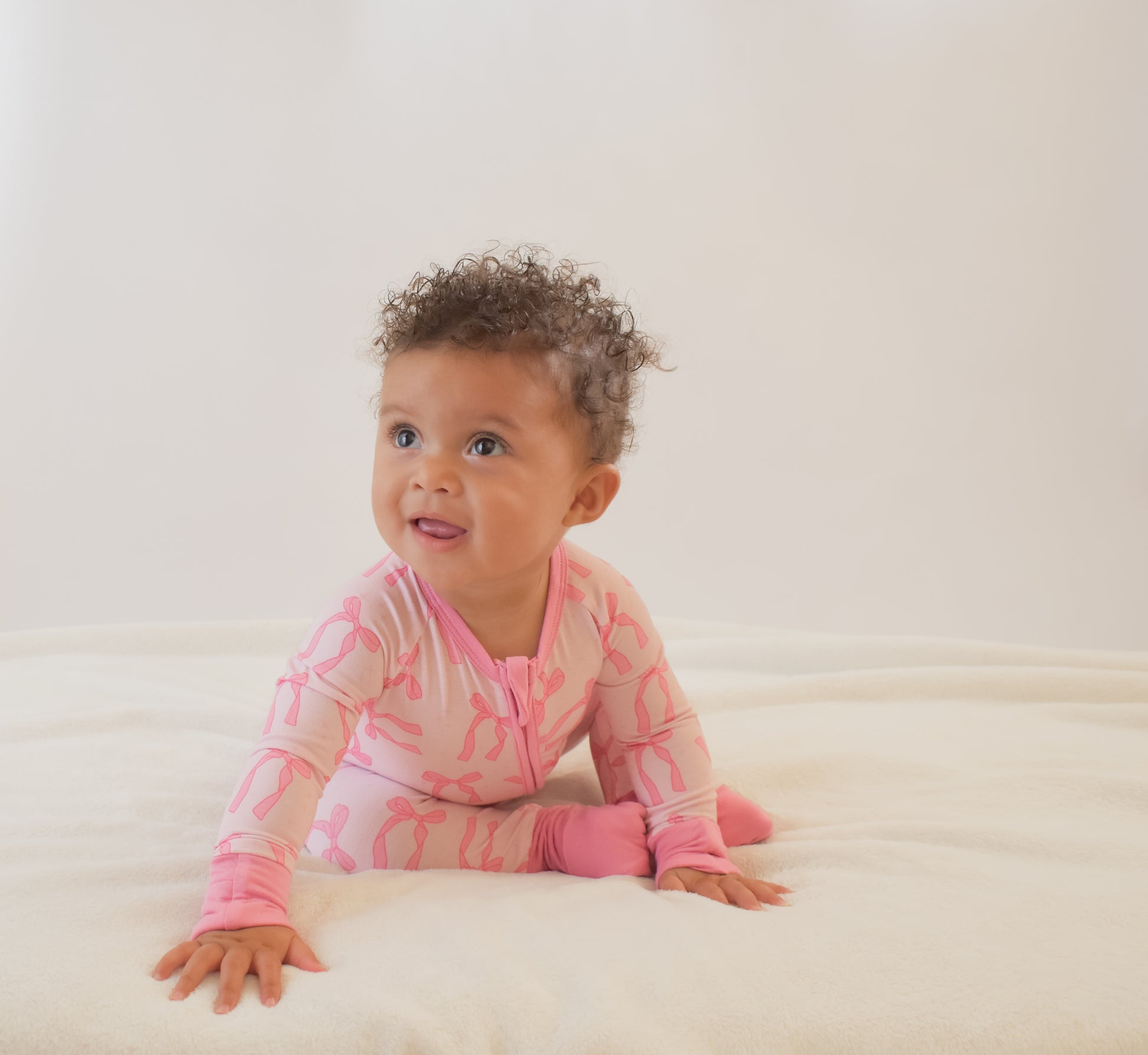 Baby wearing a convertible pajama with a pattern on a white background