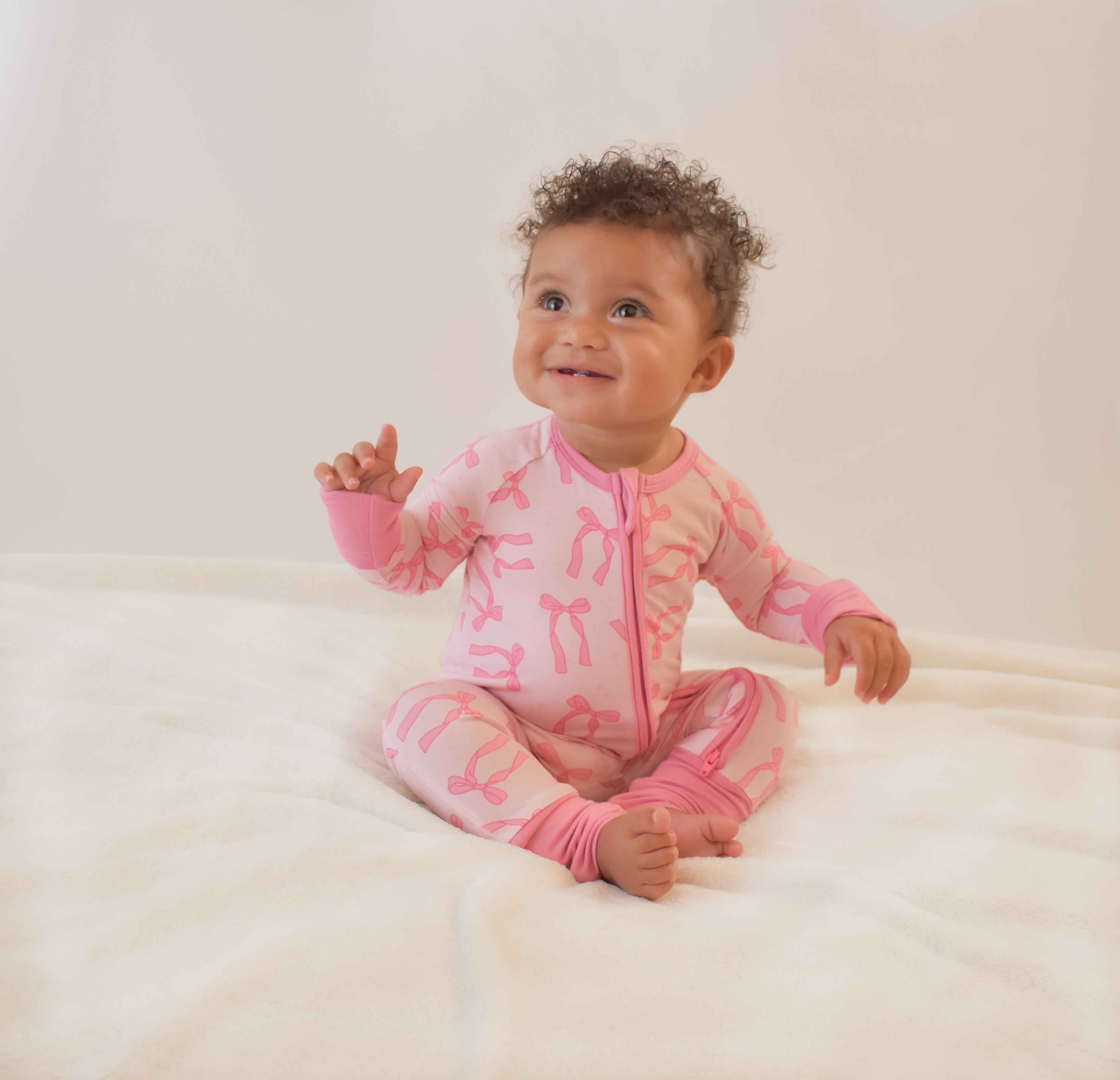 Baby wearing a pink pajama with pink bows prints