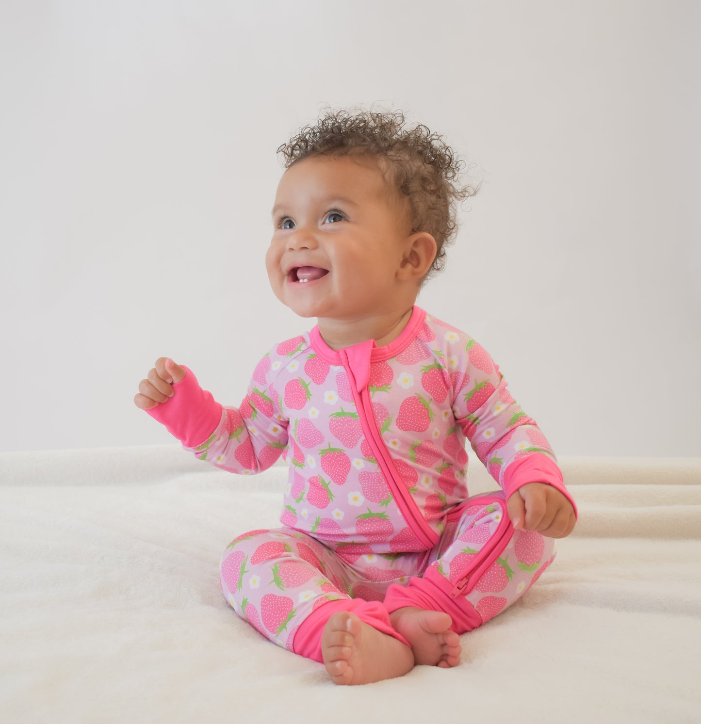 Happy baby wearing a pink strawberry convertible pajama with double zipper 