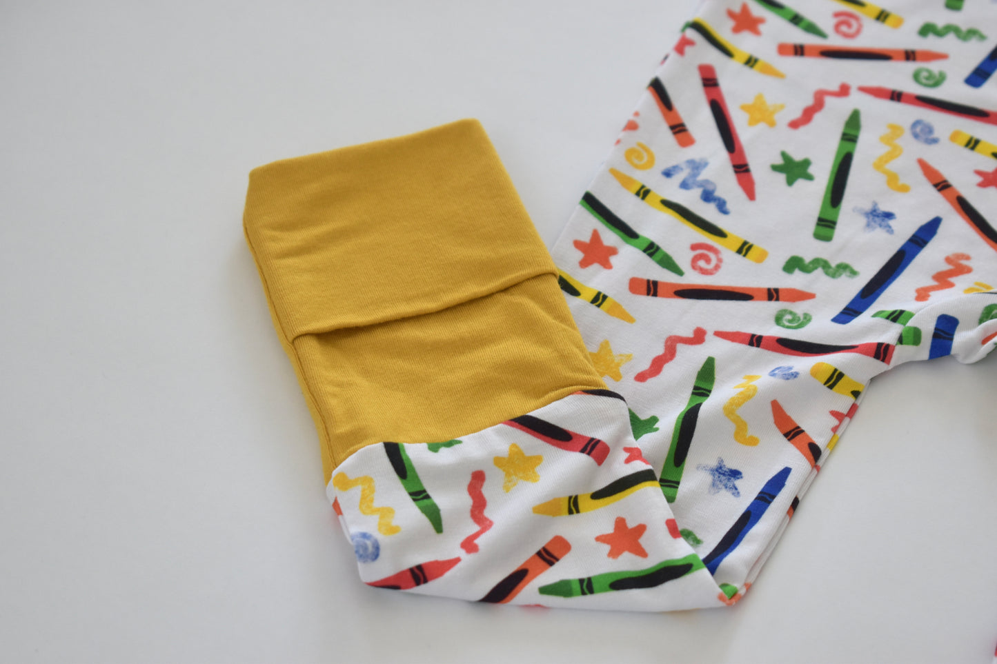 Yellow fabric and a white fabric with crayon pattern on a white background