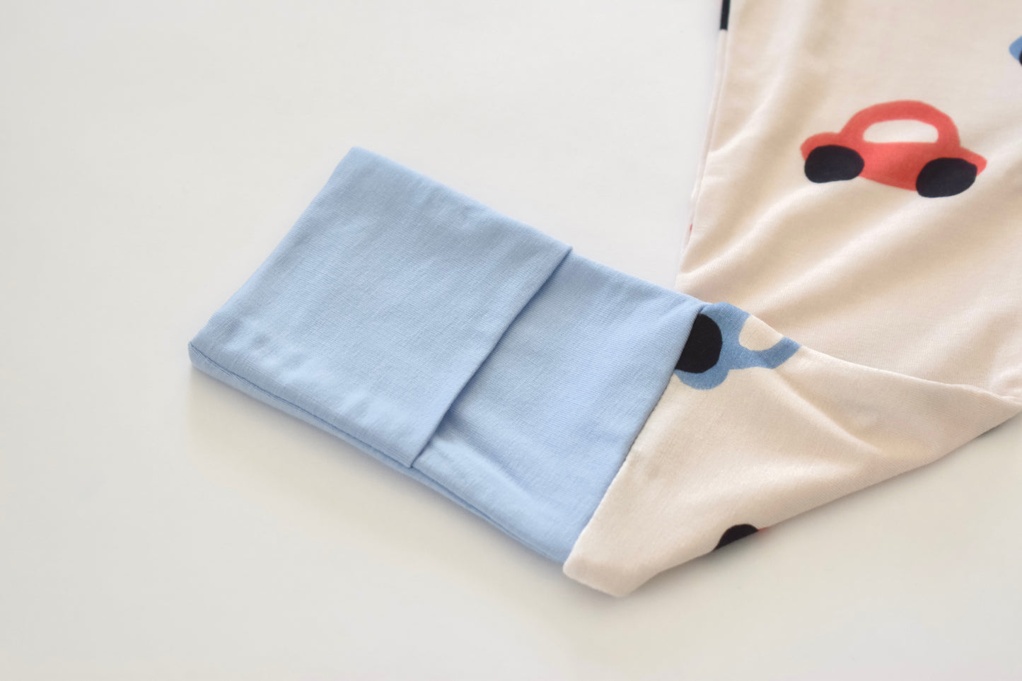 Light blue fabric with a car design on a beige surface